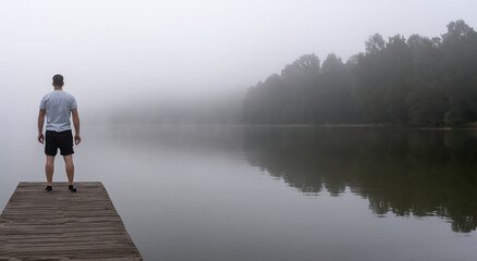 Fototapeta na wymiar lonely man on a misty dock