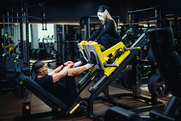 Lady in carnaval mask trainer. Halloween person in dark gym.
