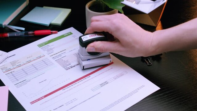 Caucasian Woman Stamping "Past Due" on Electricity Utility Bill. Shot with ARRI Alexa in ArriRaw at 120 fps, exported 23.98 fps QuickTime Apple ProRes 422 HQ.