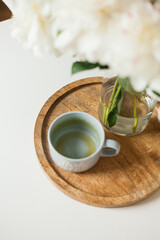 Home cozy interior. Bouquet of peonies in a glass vase on a wooden coffee table. Spring.