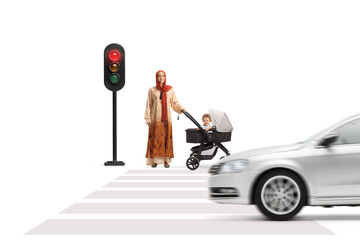 Mother wearing a hijab and waiting at traffic lights with a baby in a stroller