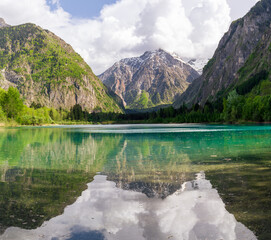 Reflection of the mountains in the water of lake Buclet in the middle of French Alps.