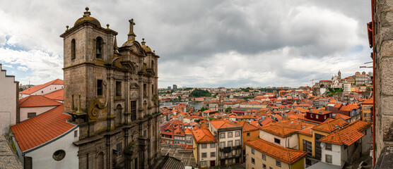 Fototapeta premium Panorama Porto town, Portugal. Wide angle view from the top, red roofs, church tower in background. Darker and moody sky.