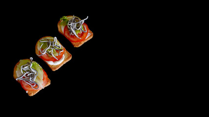  toast with eels, lettuce, mayonnaise and tomato. on a black background   