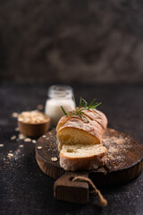 Sliced artisan baguette bread on wooden coaster and rustic background. Sourdough bread.