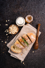 Sliced artisan baguette bread on wooden coaster and rustic background. Sourdough bread.