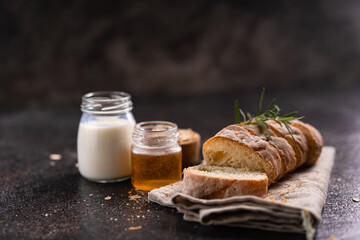 Sliced artisan baguette bread on wooden coaster and rustic background. Sourdough bread.