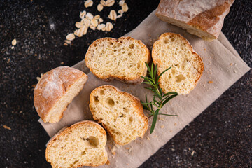 Sliced artisan baguette bread on wooden coaster and rustic background. Sourdough bread.