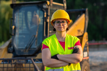 cheerful female excavator operator on construction site. Woman construction apprentice learning to drive heavy equipment © Nenad
