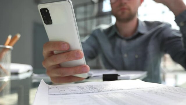uses smrt phone for making calls or reading news online. Businessman reviews documents