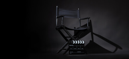 Black director chair and Clapper board or slate on black background. - obrazy, fototapety, plakaty