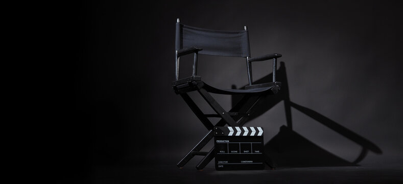 Black director chair and Clapper board or slate on black background.