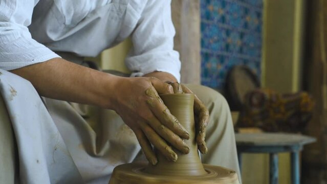 The man makes a jug out of the clay