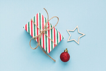 Christmas composition with eco crafted gift, dried orange, cone, xmas tree fir branch, gift and wood star. Natural minimal new year concept, top view, flat lay, isolated, copy space on red background