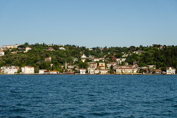 Touristic sightseeing ships in Golden Horn bay of Istanbul and mosque with Sultanahmet district against blue sky and clouds. Istanbul, Turkey during sunny summer day