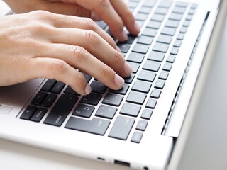 Fototapeta na wymiar Close up of a woman typing on a keyboard