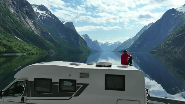 Traveler Enjoying Scenic Mountainscape from the Roof of His RV