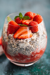 Healthy chia pudding in a glass with fresh strawberries made from almond milk and berry juice. Perfect breakfast for healthy start of the day