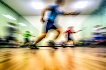 An action-packed scene of a racquetball game, the players moving so fast they're just a blur against the backdrop of the vivid court