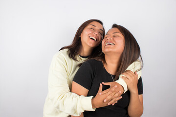 photograph of a happy female couple embracing on a light studio background. Concept of people and human relationships.