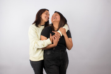 photograph of a happy female couple embracing on a light studio background. Concept of people and human relationships.