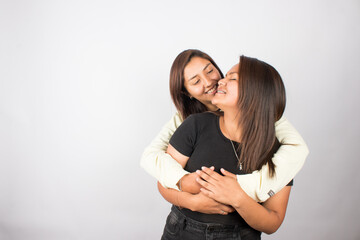 photograph of a happy female couple embracing on a light studio background. Concept of people and human relationships.
