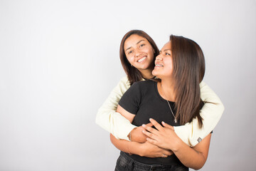 photograph of a happy female couple embracing on a light studio background. Concept of people and human relationships.