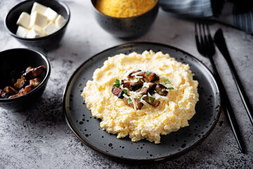 Corn porridge with fried bacon, parsley and Feta cheese in a bowl