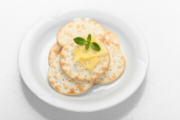 snack of blacha with cheese, decorated with basil leaves on a white plate
