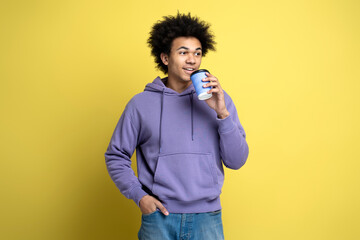 Smiling African American man wearing stylish hoodie, holding cup of coffee