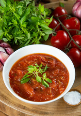 Homemade tomato sauce with tomatoes, basil, garlic and salt on wooden table