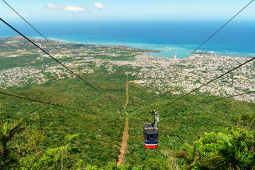 View of Puerto Plata, forest, ocean, and the cable car from the top of Mount Isabel de Torres - cable car has partly descended - obrazy, fototapety, plakaty