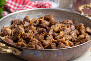 Muslims Traditional Sacrifice holiday food lamb, Turkish roasted meat in copper pot on table top. Turkish Kavurma. (Turkish name; Kurban kavurma)