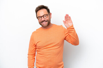 Middle age caucasian man isolated on white background saluting with hand with happy expression © luismolinero