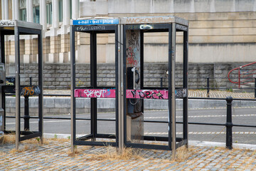 Fototapeta na wymiar Old vandalised telephone boxes in Bristol city centre