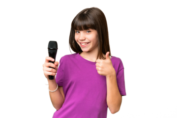 Little singer girl picking up a microphone over isolated background with thumbs up because something good has happened
