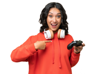 Young Argentinian woman playing with a video game controller over isolated background with surprise facial expression