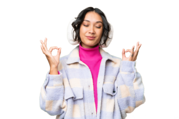 Young Argentinian woman wearing winter muffs over isolated background in zen pose