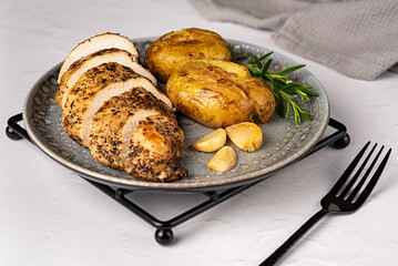 Food photography of roasted chicken, potato, garlic, rosemary, fork, knife, towel, meal, food