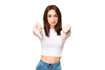 Fototapeta na wymiar Young caucasian woman over isolated chroma key background showing thumb down with two hands