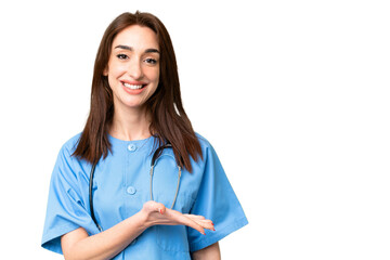 Young nurse woman over isolated chroma key background presenting an idea while looking smiling towards