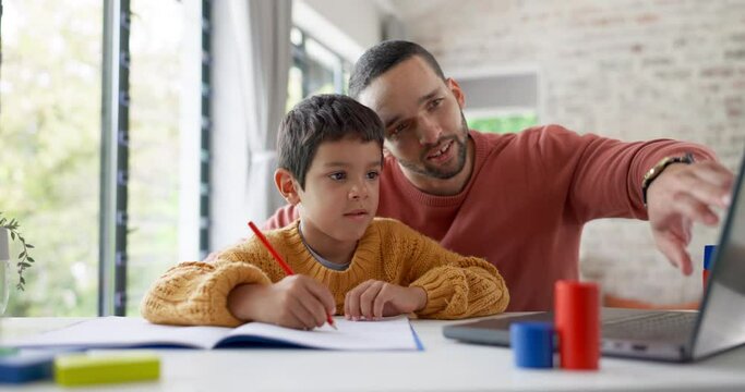 Father, Boy Child And Homework With Laptop, Writing And Helping Hand For Education, Childhood Development Or Care. Man, Dad And Male Kid With Home School, Notebook And Computer With Teaching At Desk