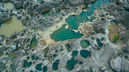 Aerial view above 3000 bok unseen beautiful rock of Mekong river..Amazing big rock with many holes..green water trapped in a hole of huge rocks..amazing rock green water in the hole background.