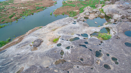 aerial photography around grand canyon in Mekong river. .3000 bok mean 3000 holes,holes eroded into the rock along Mekong river. .color of water inside the holes after low tide is emerald green