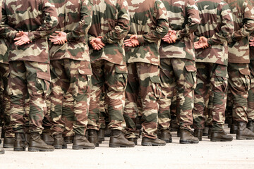 Soldiers in a relaxed position during the ceremony. Military camouflage outfit.