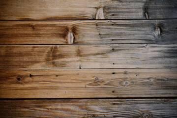 Dark stained reclaimed wood surface with aged boards lined up. Wooden floor planks with grain and texture.