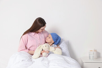 Childhood cancer. Mother and daughter with toy bunny in hospital