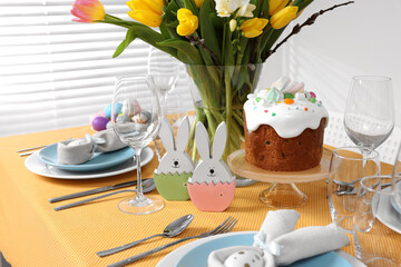 Festive table setting with traditional Easter cake and vase of tulips