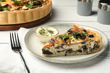 Piece of delicious quiche with mushrooms and parsley served on white table, closeup