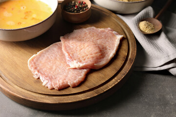 Cooking schnitzel. Raw pork slices and other ingredients on grey table
